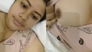 A young girl flaunts her natural breasts in a seductive video